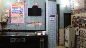 A reception area with a sign listing services like air tickets and car rentals. - Delhi Inn (New Delhi)