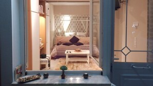 A bedroom with a bed, bedside table, and a small plant. - Tango - Apartments on the Beach (Corfu)