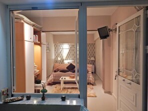 A bedroom with a bed, bedside table, and a TV mounted on the wall. - Tango - Apartments on the Beach (Corfu)