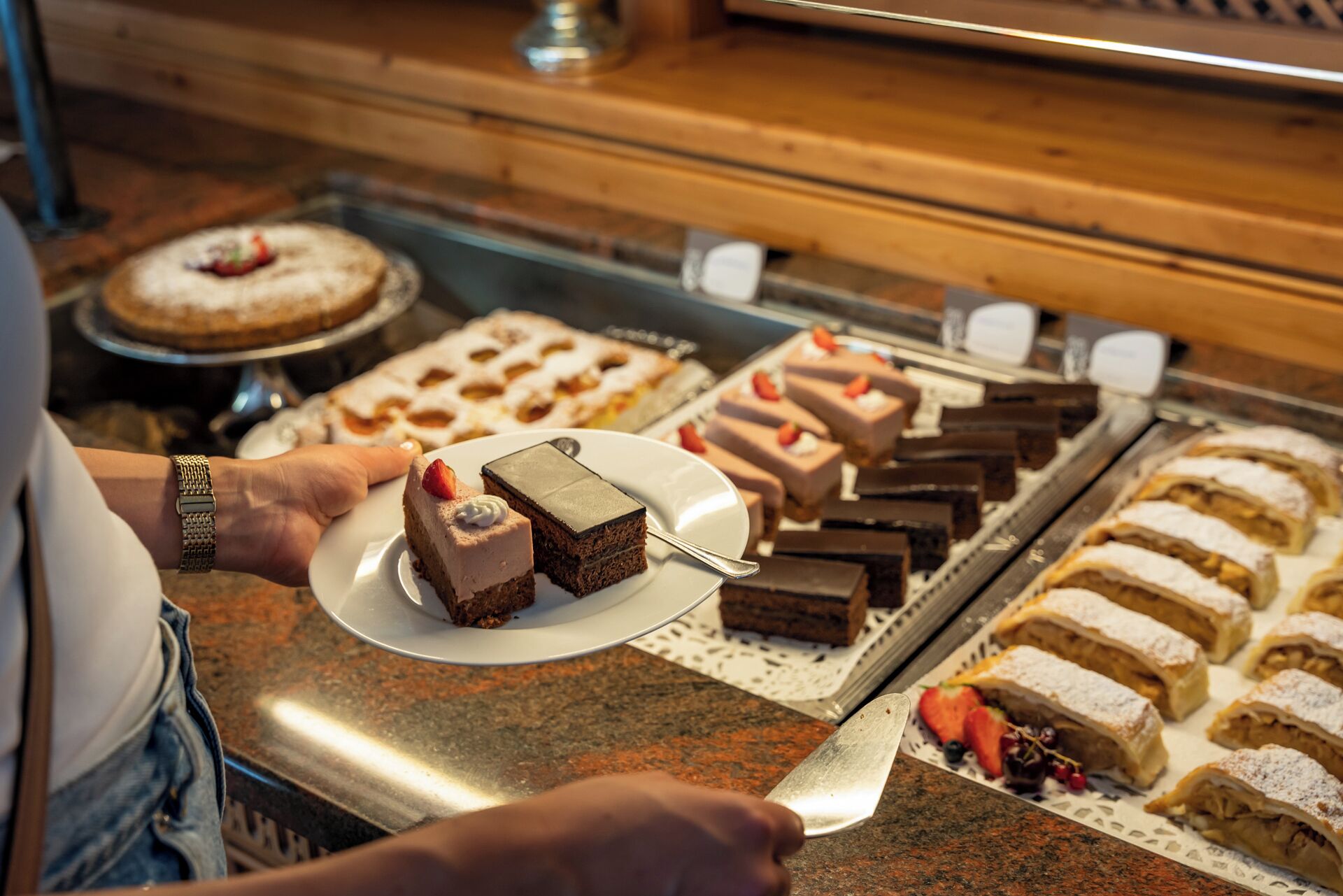 A dessert display with various cakes and pastries.