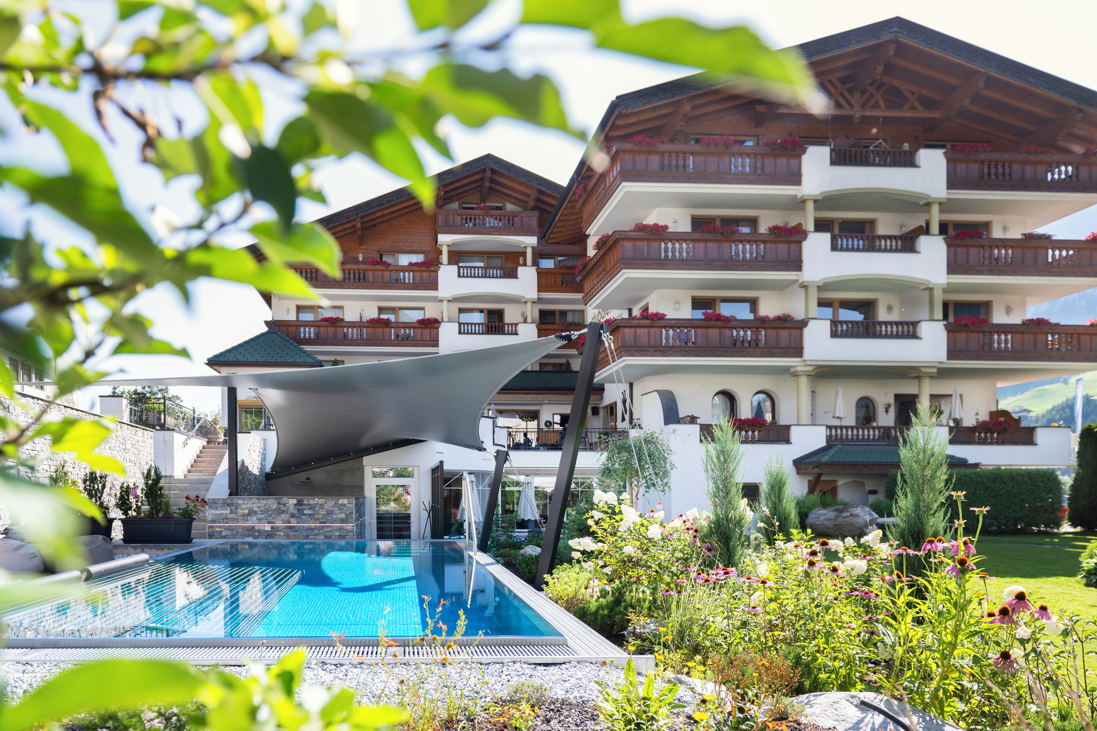 Un hotel moderno con piscina, zona de estar al aire libre y jardín.