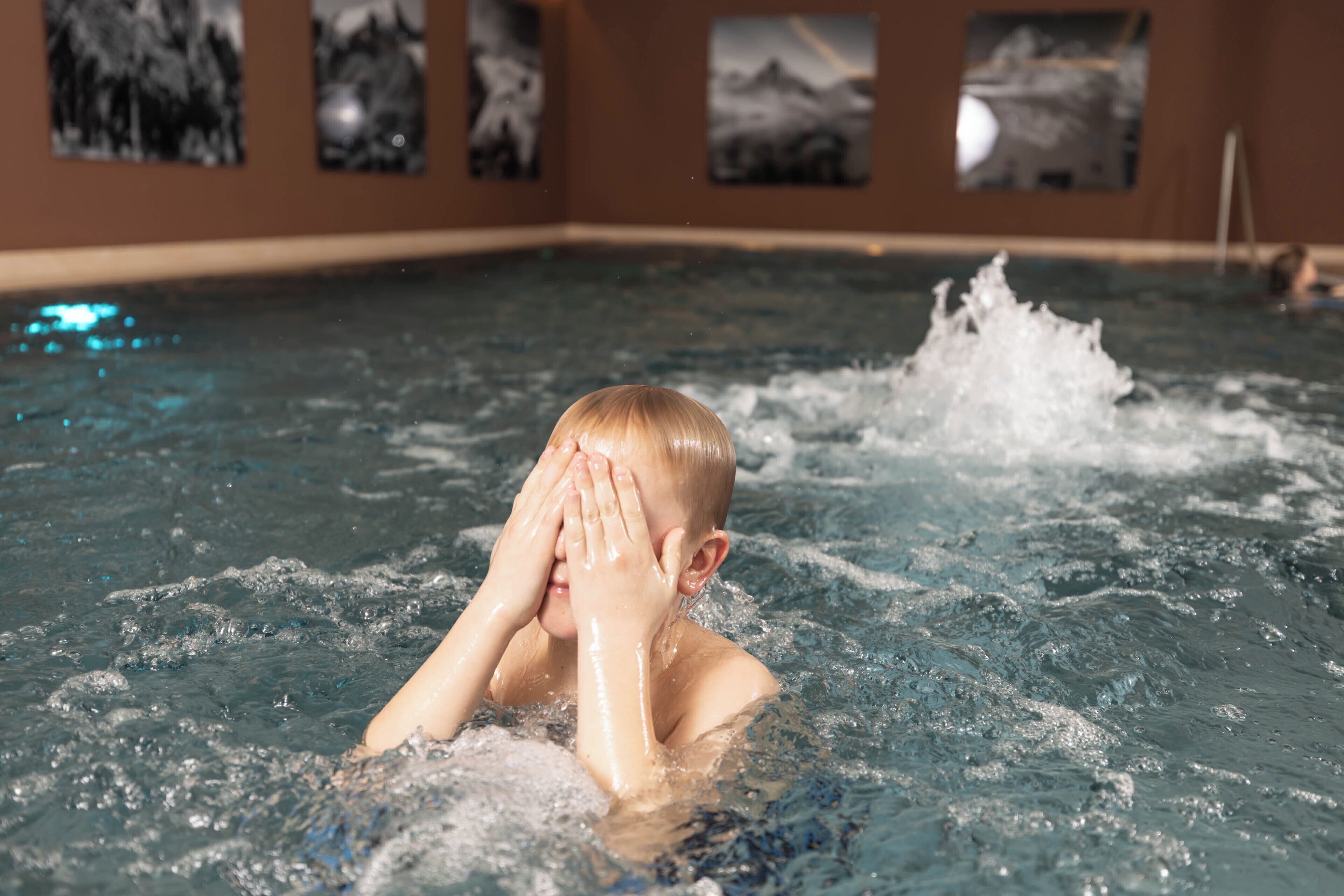 Iemand in een zwembad, met opspattend water.