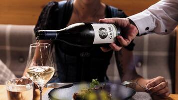 A person pouring wine into a glass.
