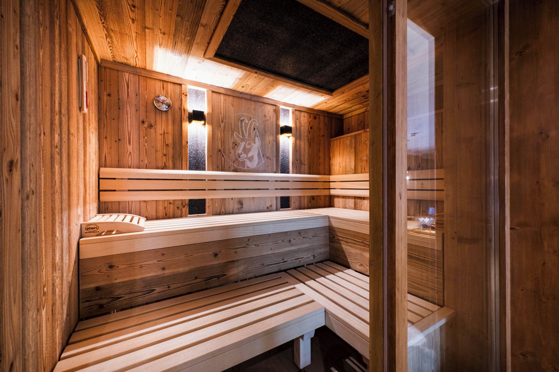 Una sauna in legno con panche e un lucernario.