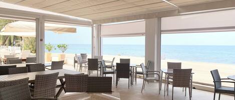 An outdoor patio with wicker furniture and a view of the beach.