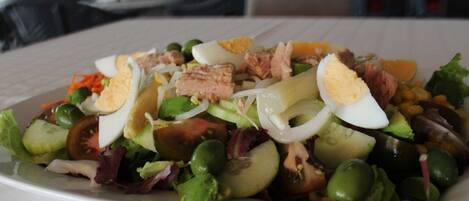 A plate of mixed salad with various vegetables and proteins.