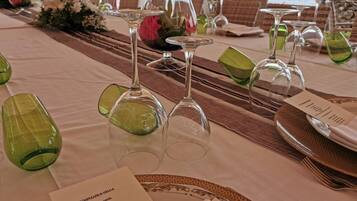 A table set for a meal with a menu card, glasses, and a view of the ocean.