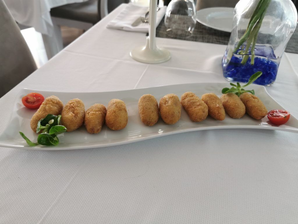 Une assiette blanche contenant des aliments frits, posée sur une table.