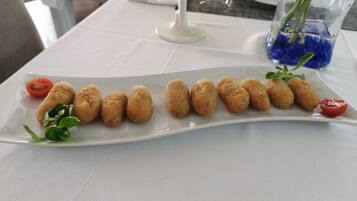 Une assiette blanche contenant des aliments frits, posée sur une table.