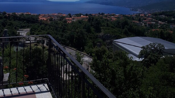 A balcony with a view of a coastal town, mountains, and a clear blue sky. - Apartments sv. Anton (Kastav)