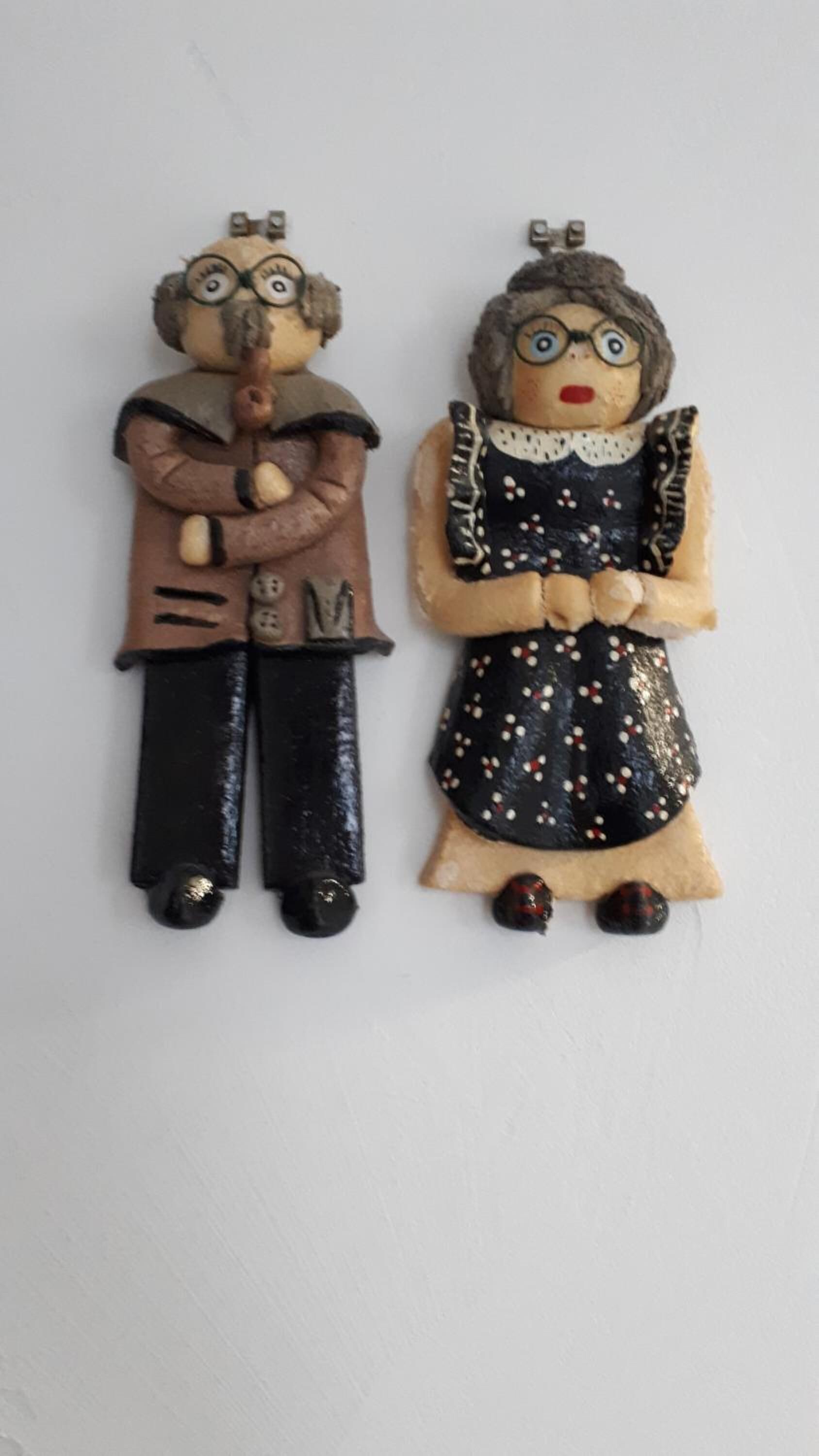 Deux statuettes, une masculine et une féminine, se tiennent côte à côte.