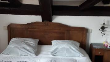 A bed with a wooden headboard and white linens.