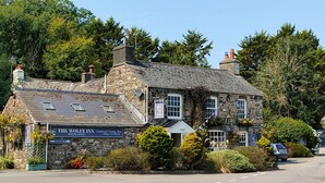 A traditional stone building with a sign for 'The Wolf Inn' and a 'Main Car Park' sign.