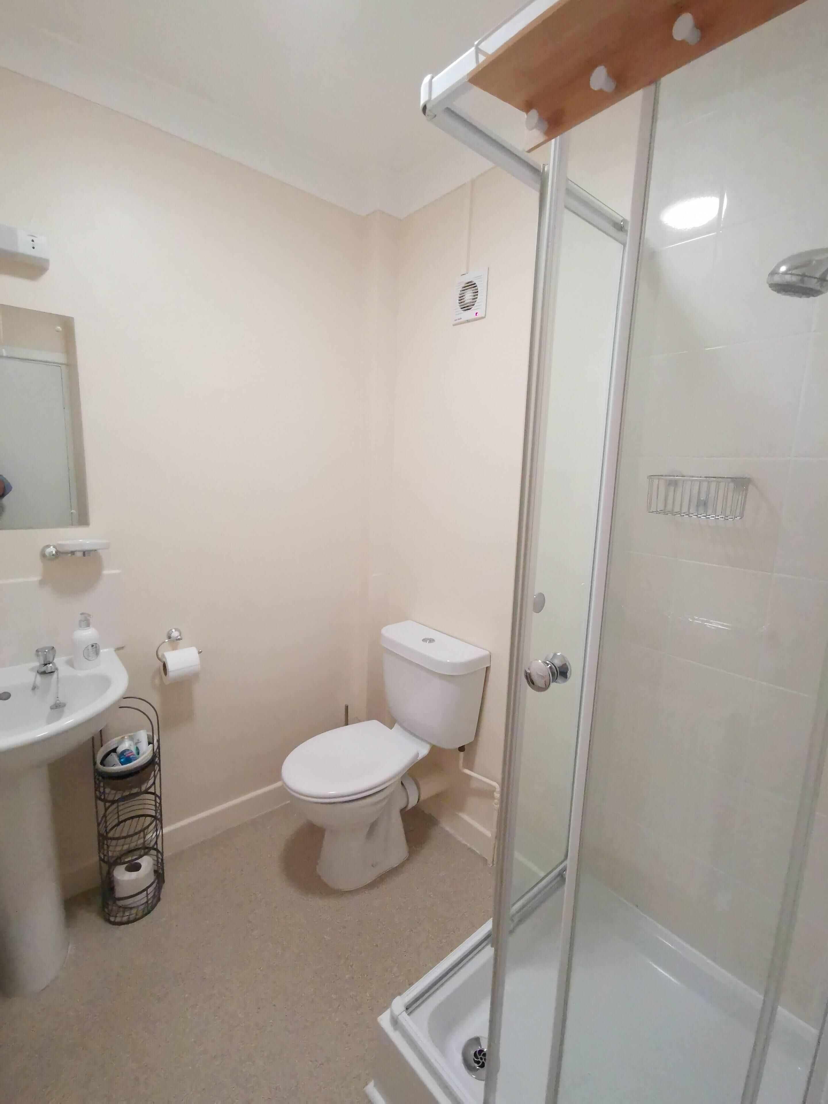 A bathroom with a toilet, sink, and shower.