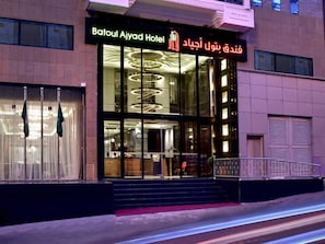 The Batoul Ayyad Hotel with a glass facade, a staircase leading to the entrance, and a modern interior design. - Batoul Ajyad (Makkah)