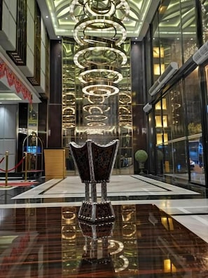 A lobby with a reflective floor, a decorative vase, and a modern chandelier. - Batoul Ajyad (Makkah)