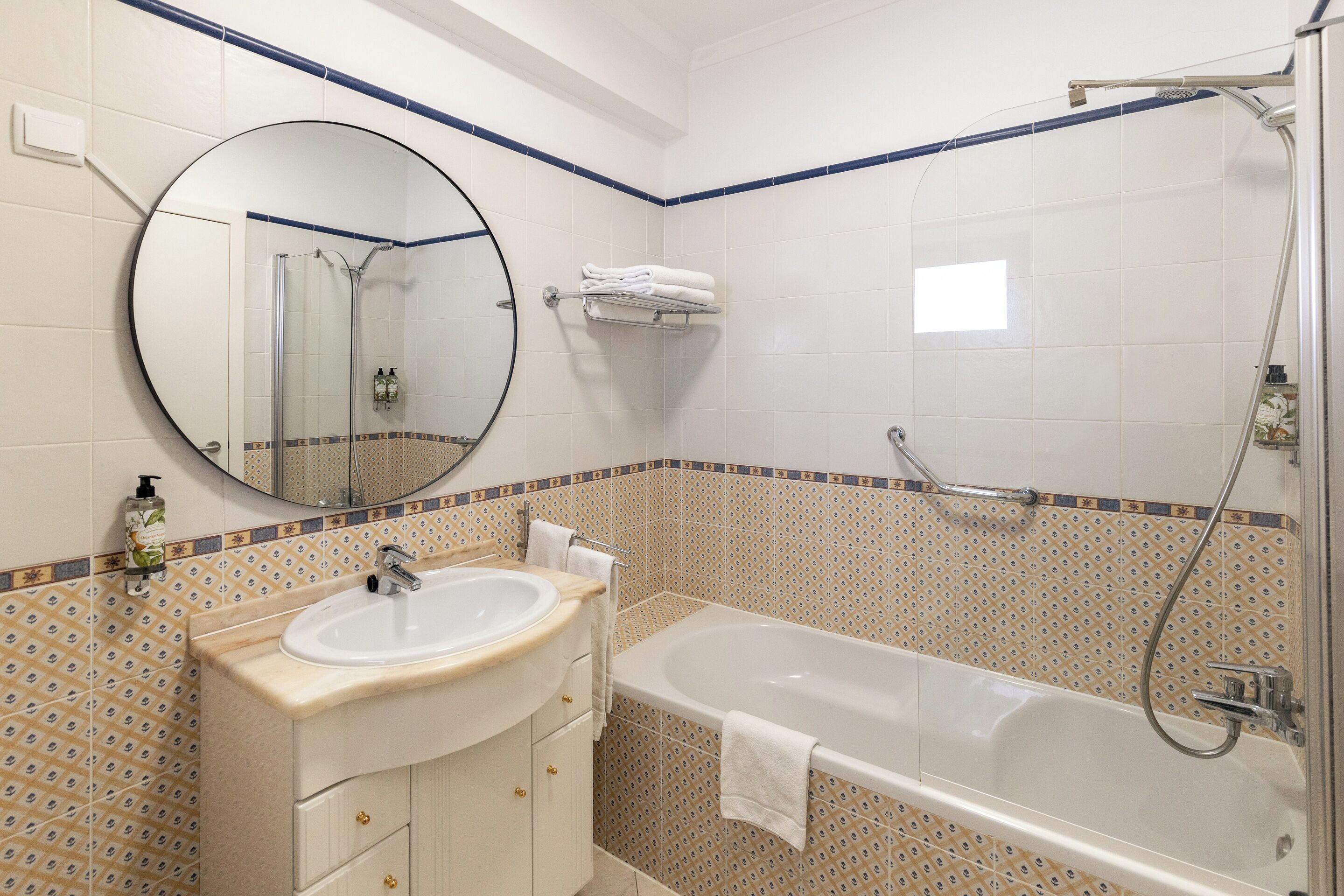 Une salle de bain avec un lavabo, un miroir et une baignoire.