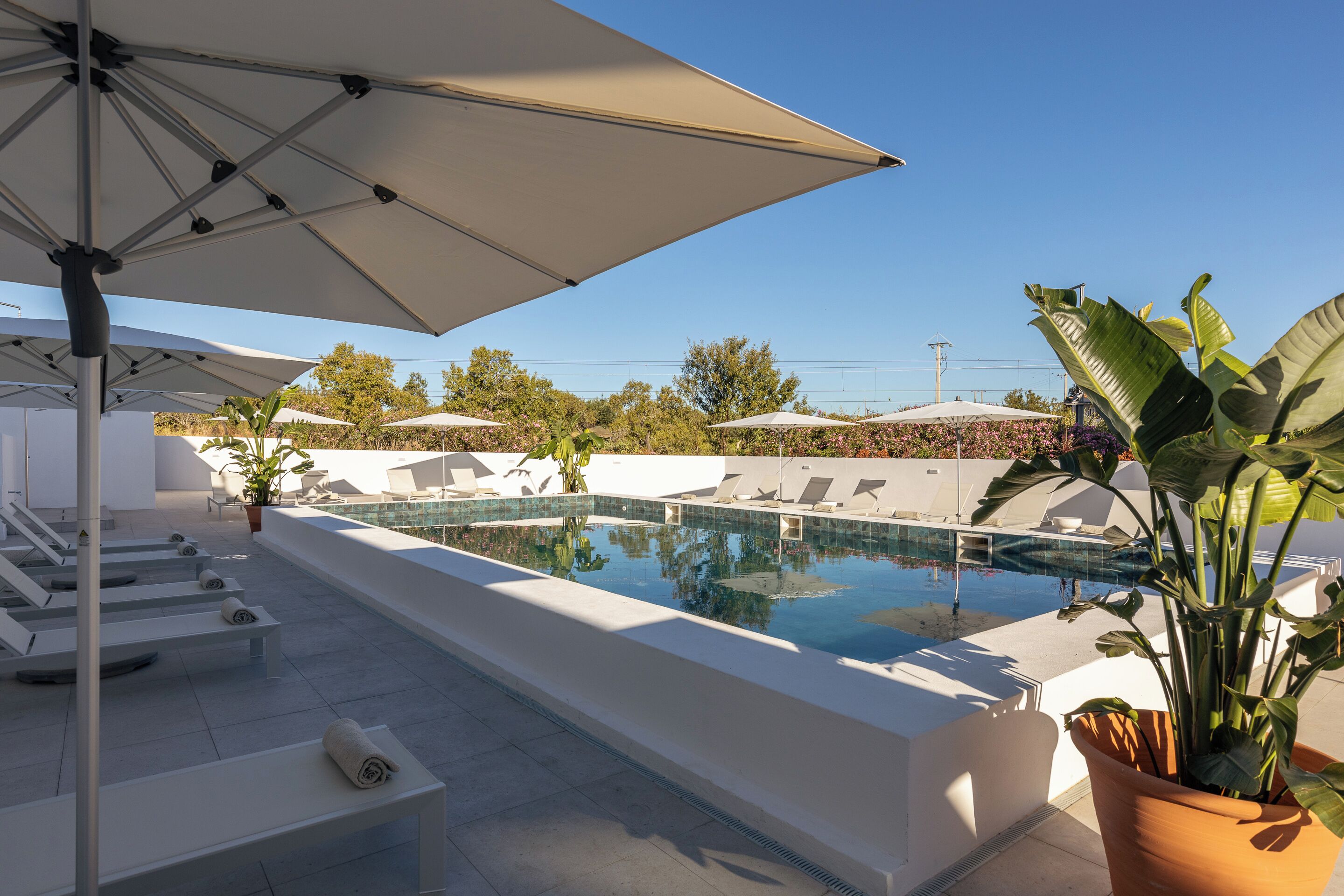 Een buitenzwembad, parasols voor strand/zwembad