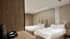 Un dormitorio moderno con dos camas, cabeceros de madera y una mesita de noche con cafetera.