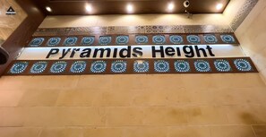 Un cartel con el texto "Pyramids Height" en una pared con baldosas decorativas.