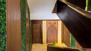 Un interior moderno con una escalera de madera, una recepción y paneles decorativos.