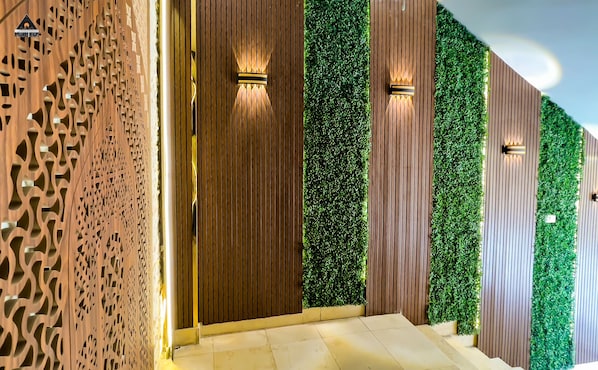 Una entrada moderna con paneles de madera y follaje verde.