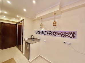 Una cocina moderna con lavavajillas integrado, un elegante salpicadero y luminarias colgantes.