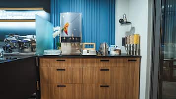 Una cocina moderna con cafetera, exhibición de frutas y estación para café.