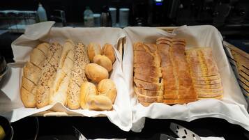 A bakery display with various types of bread and rolls.