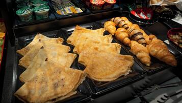 Ein Frühstücksbuffet mit verschiedenen Backwaren und Milchprodukten.