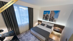 A hotel room with a bed, a desk with a computer, and a window with curtains. - Hotel Jarun (Zagreb)