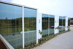 Um edifício moderno com grandes janelas de vidro e um calçada pavimentada.