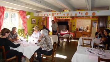Un restaurant doté de plusieurs tables, de chaises et d’un espace dédié à la salle à manger.
