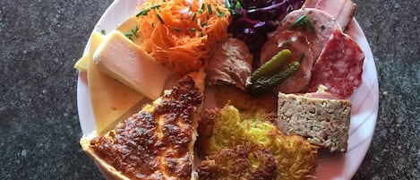 A plate with various food items including a slice of pie, a piece of meat, and a salad.