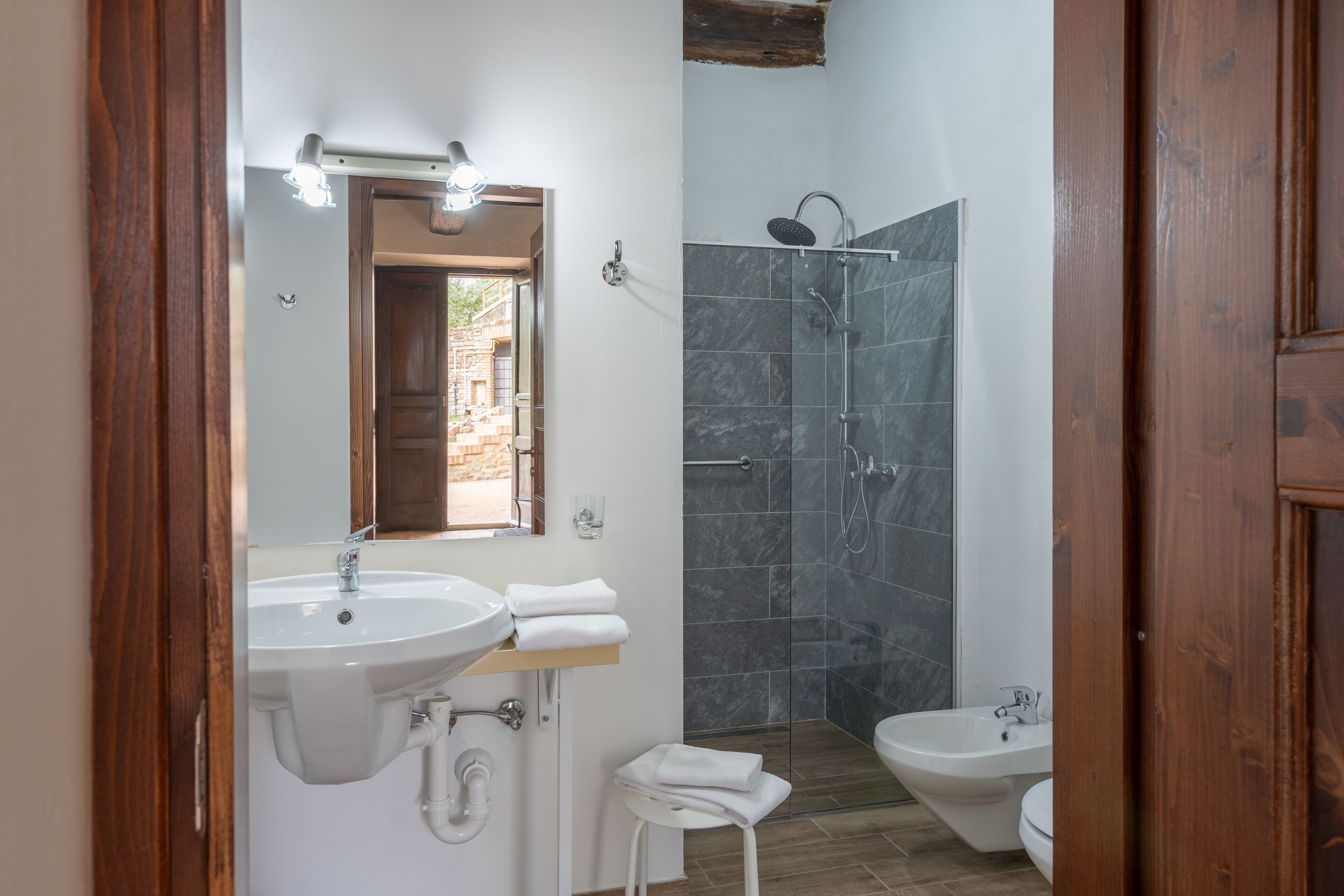 Baño con dos lavamanos, ducha y espejo.