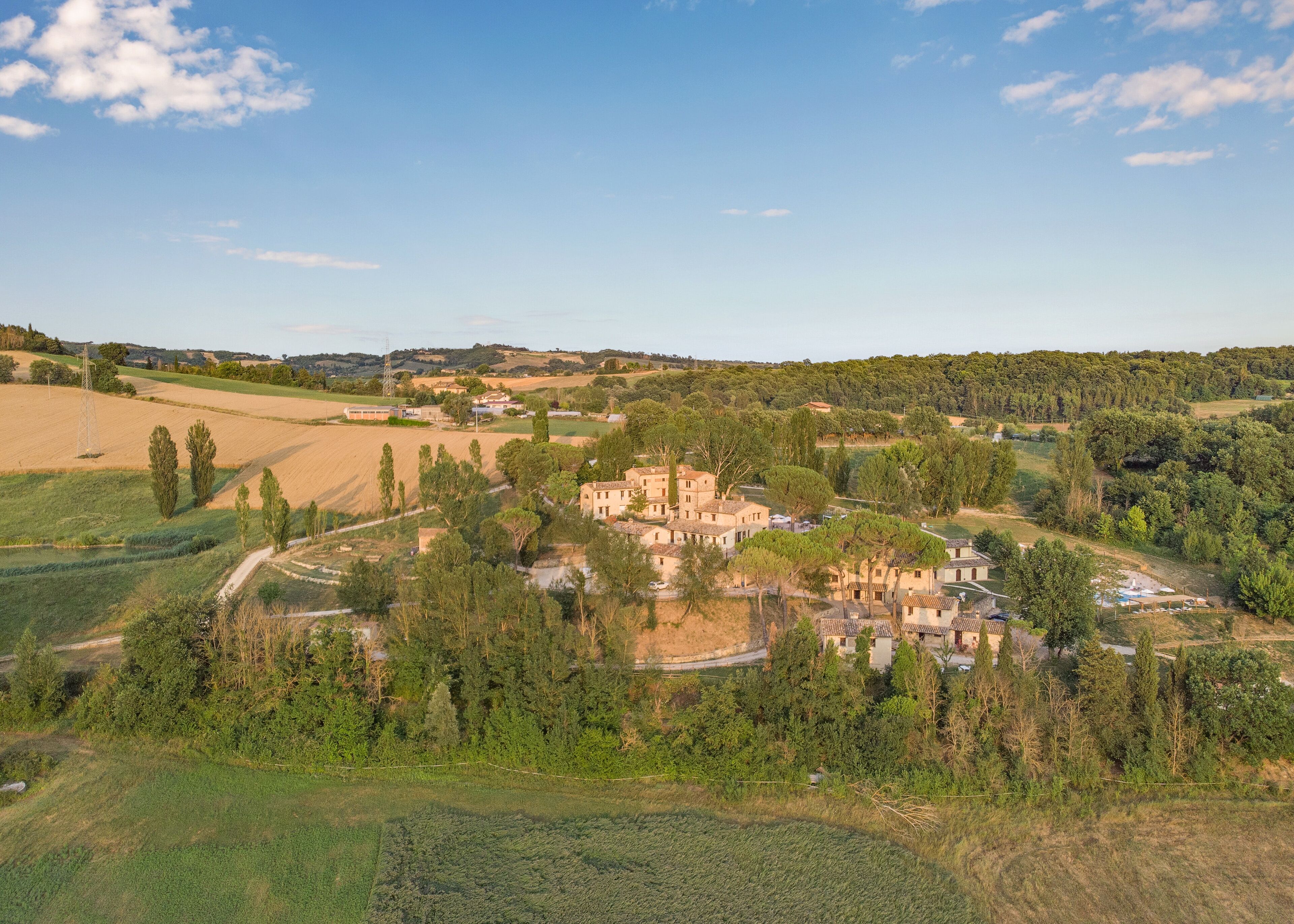 Un pueblo rural con edificios tradicionales rodeado de exuberante vegetación y campos.