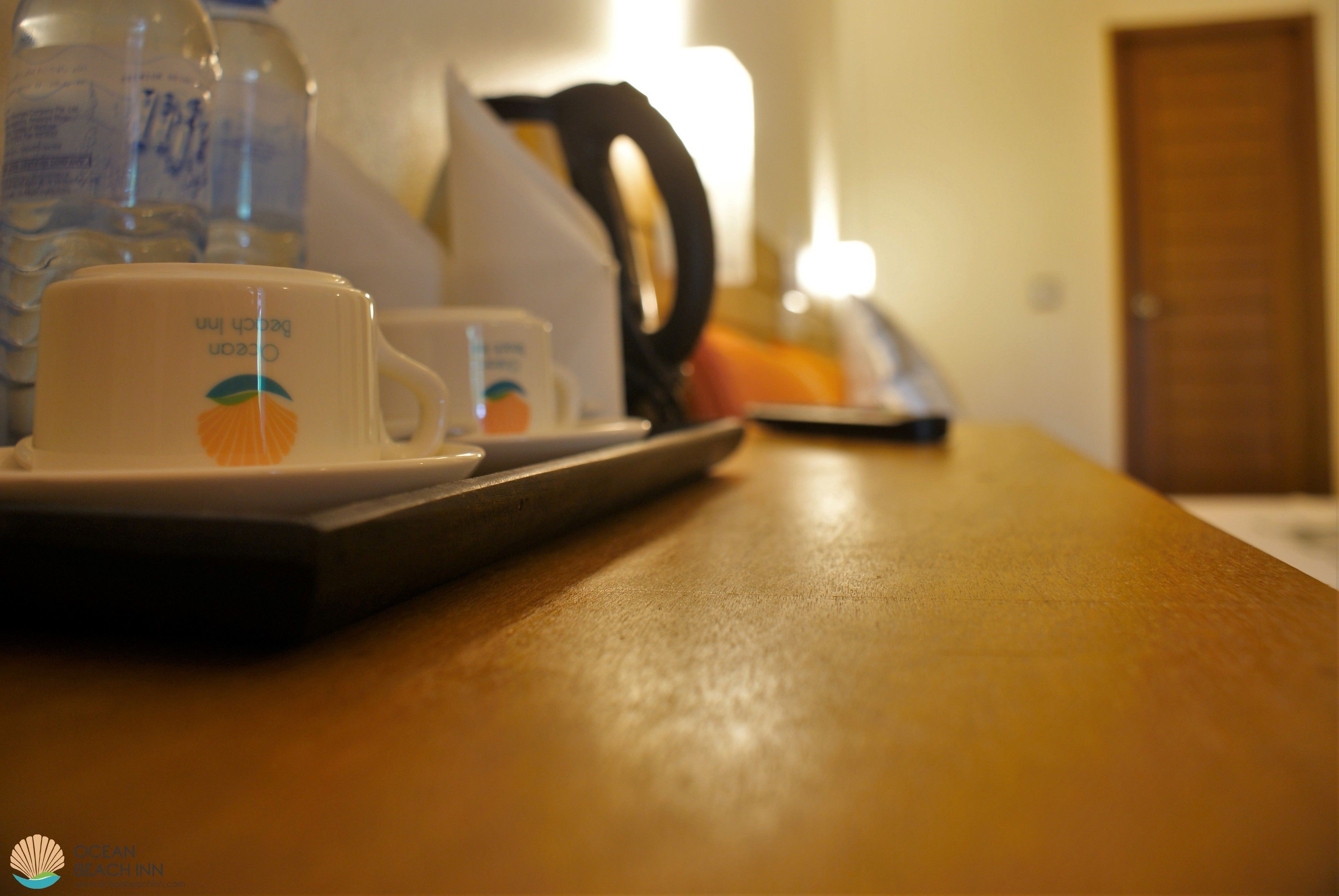 Uma mesa com uma xícara e pires, um prato pequeno e uma chaleira.