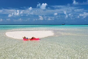 Una playa con agua turquesa cristalina y una zona de arena blanca.