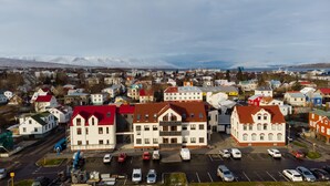 A town with a mix of modern and traditional architecture, including a prominent building with a red roof and a large, white building with a green roof. - Hrímland Apartments (Akureyri)