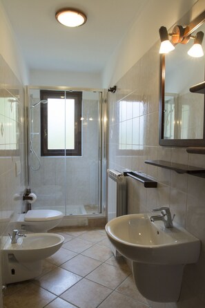 A bathroom with a shower, toilet, bidet, and sink. - Case Vacanza Perron (Sauze d'Oulx)