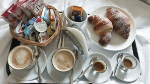 A breakfast tray with croissants, coffee, and a basket of pastries and spreads. - Art In B&B (Salerno)