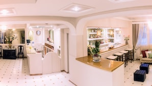 A spacious living area with a bar, seating, and a kitchen. - Hotel Sirena Beach (Corfu)