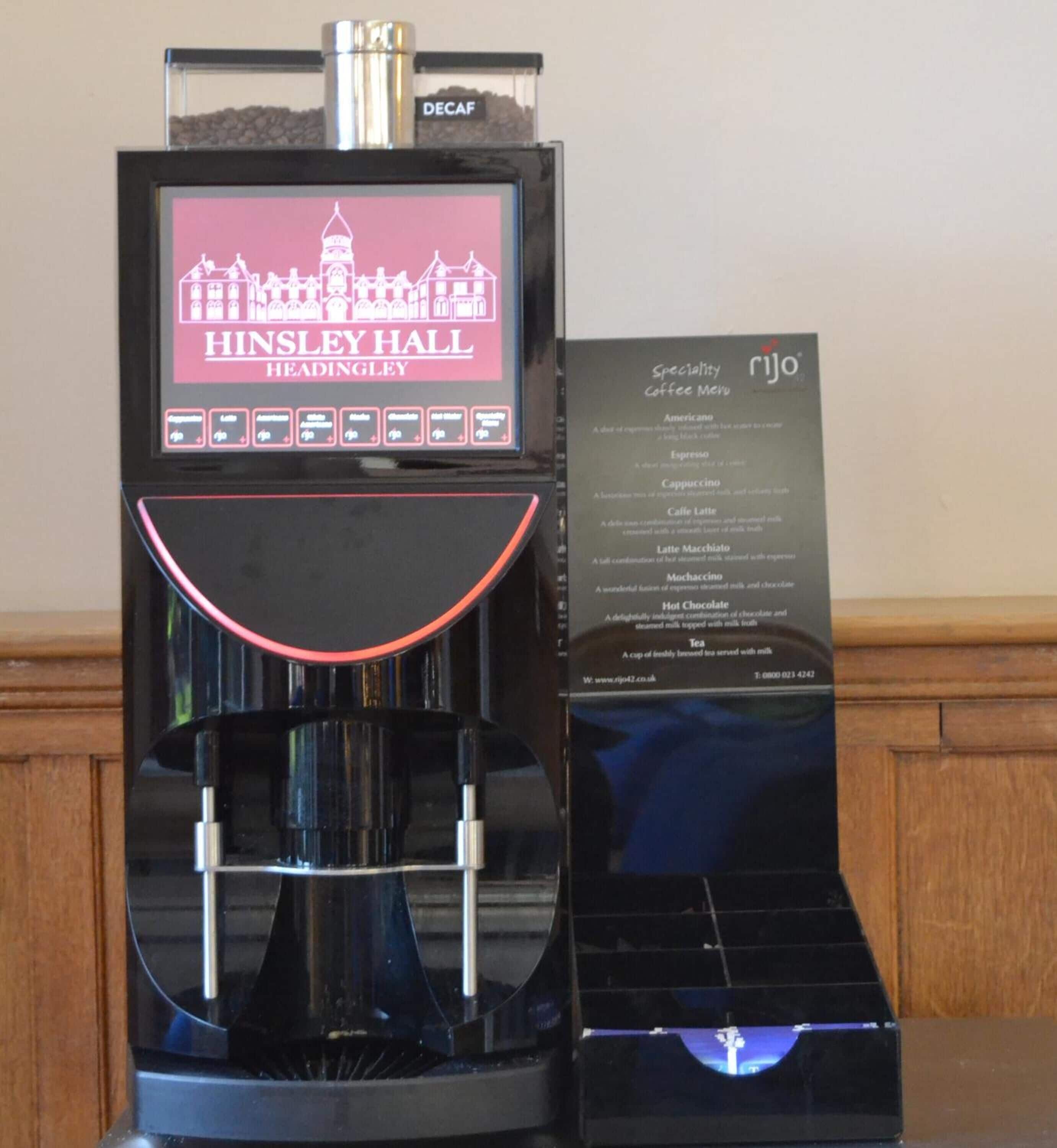 A coffee machine with a digital display and a menu sign.