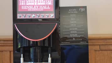 A coffee machine with a digital display and a menu sign.
