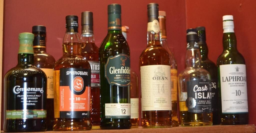 A collection of whisky bottles on a shelf.