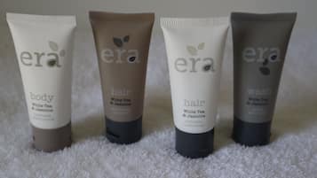 Four tubes of era body lotion, conditioner, and shampoo.