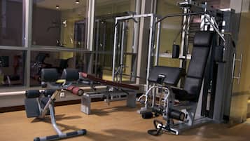 Una palestra con diverse macchine per esercizi, tra cui una leg press e una chest press.