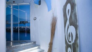 A staircase leading to a glass door with a view of a coastal landscape. - Don Carlo Rooms (Naples)