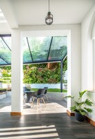 A modern interior with a glass ceiling, a dining area with chairs, and a potted plant.