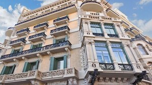 A multi-story building with ornate balconies, large windows, and classical architectural details. - Hotel Ginebra (Barcelona)